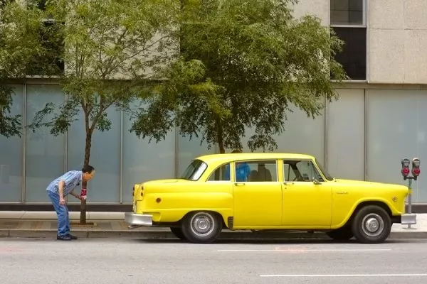 A picture of a man checking out his classic car