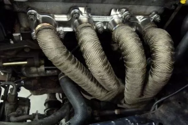 A picture of a car's exhaust headers wrapped with thermal wrap
