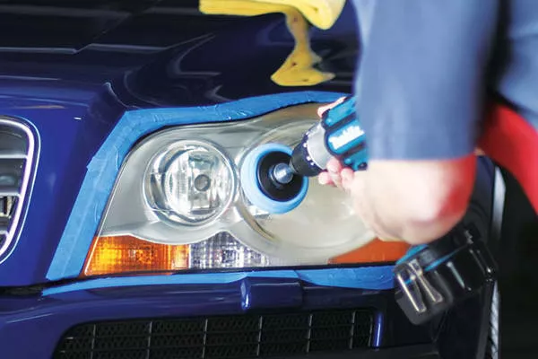 An expert cleaning the headlights