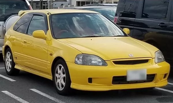 A picture of a yellow Honda Civic Type R on a parking lot
