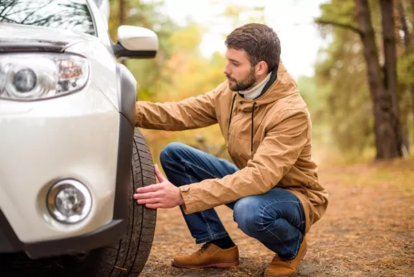man checking car tire