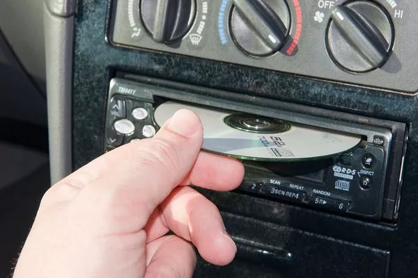 Driver putting a CD on the car stereo