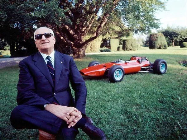 Enzo Ferrari Posing in front of Ferrari Race Car