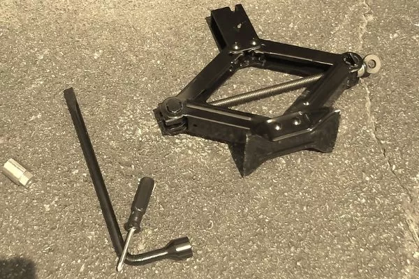 A picture of a jack and tire wrench