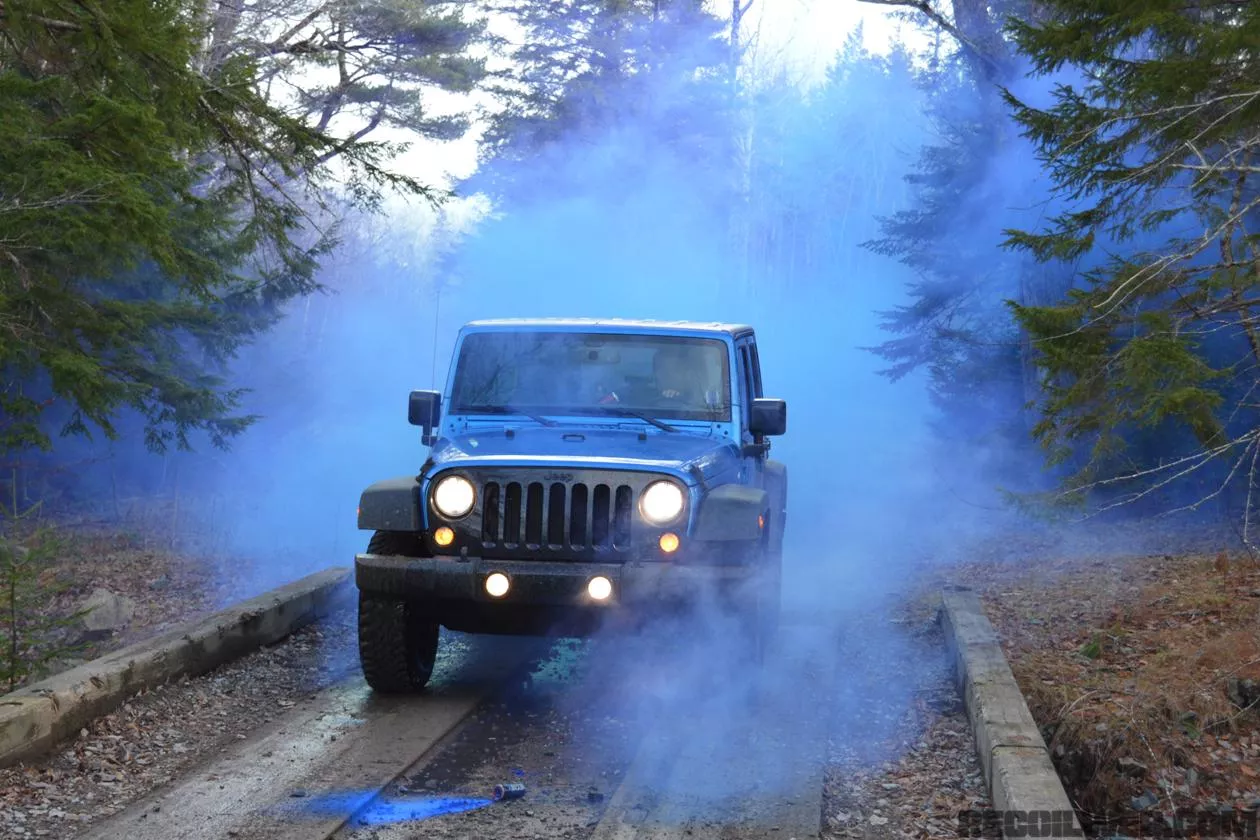 A blue Jeep emitting blue smoke