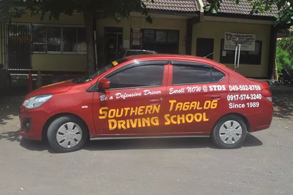 A Southern Tagalog Driving School training vehicle parked near their office. Southern Tagalog Driving School training vehicle
