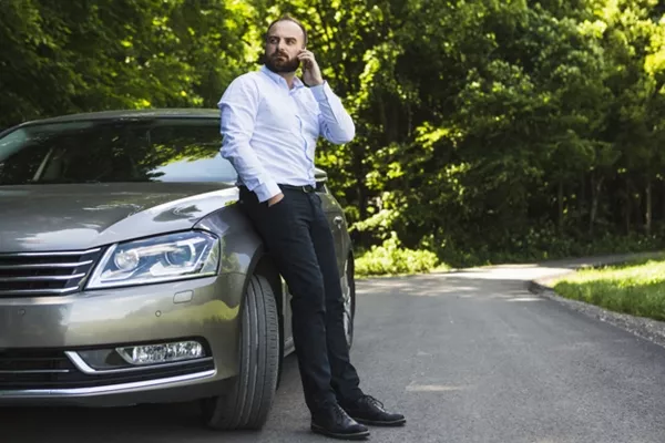 man leaning on car