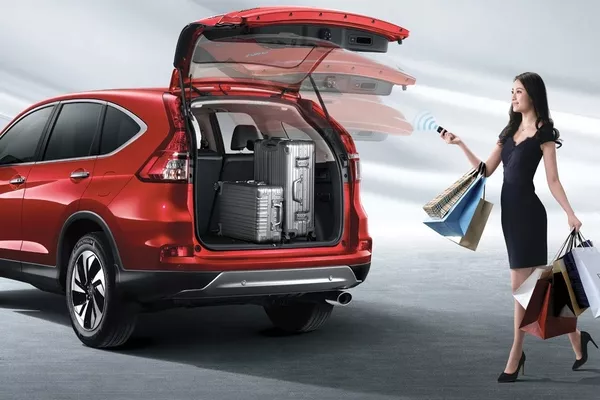 Woman carrying shopping bags and a red car