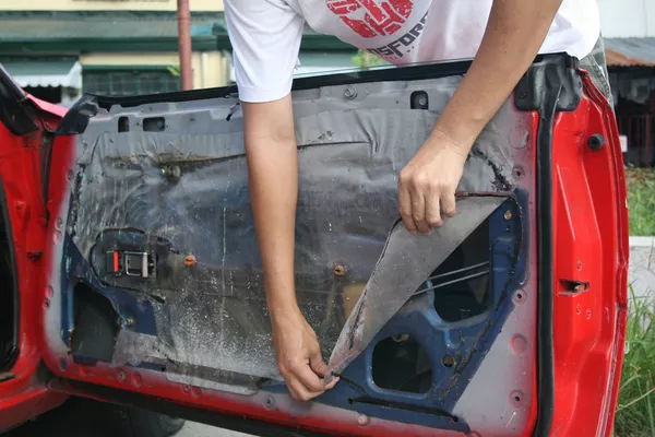 Man removing the car door panel