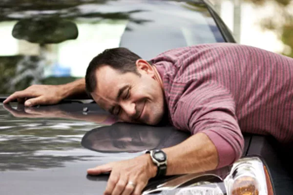 a man hugging his car