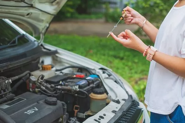 Woman checking the car engine
