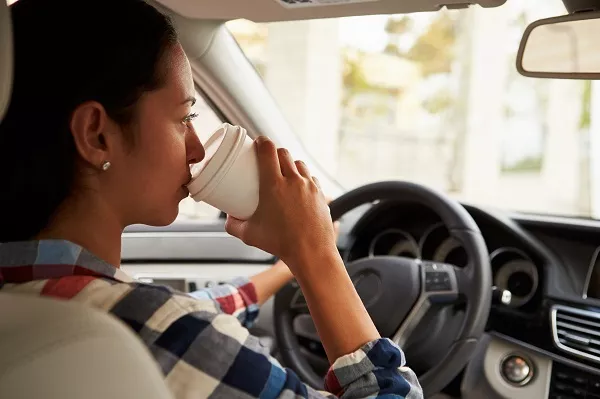 Texting and eating are one of the top reasons why women may lead to a traffic violation or accidents Man drinking coffee while driving