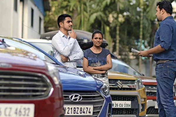 Bringing a friend can give you honest opinions about the vehicle you're buying and help you make a decision man and a friend buying a car