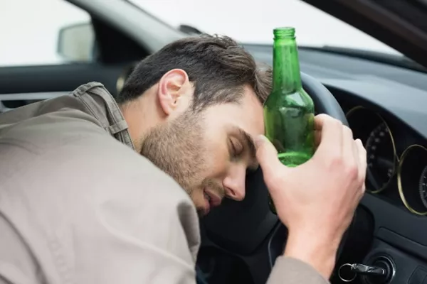 Drinking while driving is not always a good thing because it can harm your and other's safety man drinking in car