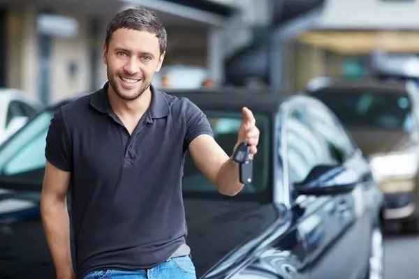 man is smiling with a car key