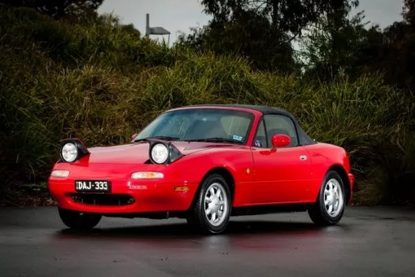 A picture of a red Mazda Miata NA.