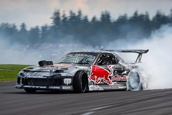 A picture of a Mazda RX-7 drift car performing a drift