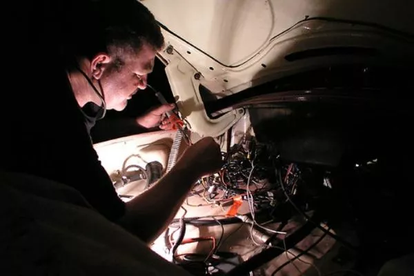A picture of a man fixing his VW Beetle