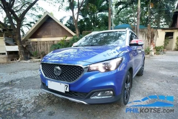 A picture of a blue MG ZS at a resort car park