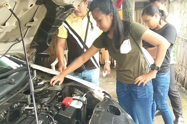 A picture of an MJ Driving School instructor with his students