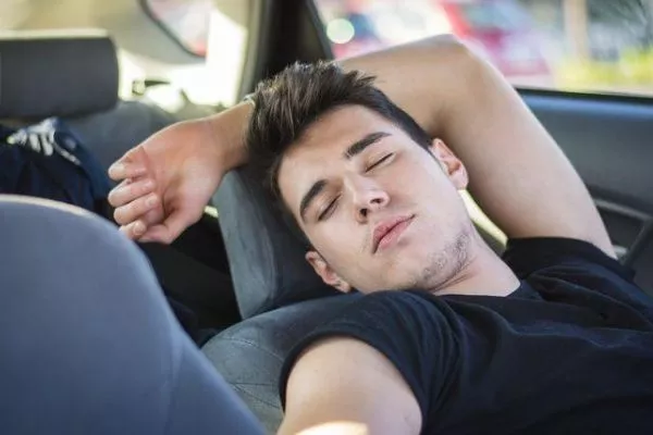 a man taking a nap in his car 