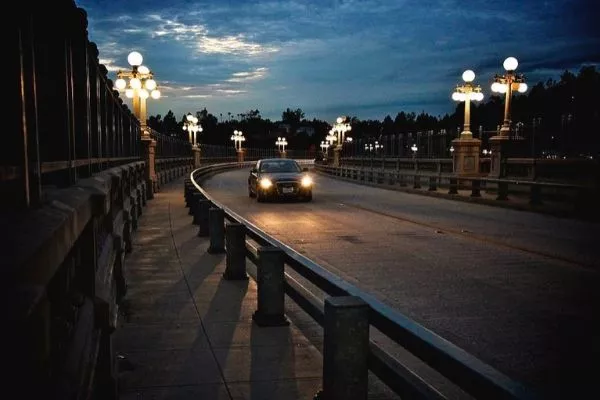 A picture of a car travelling on a road at night