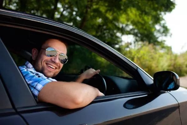 A picture of a man happily driving his car