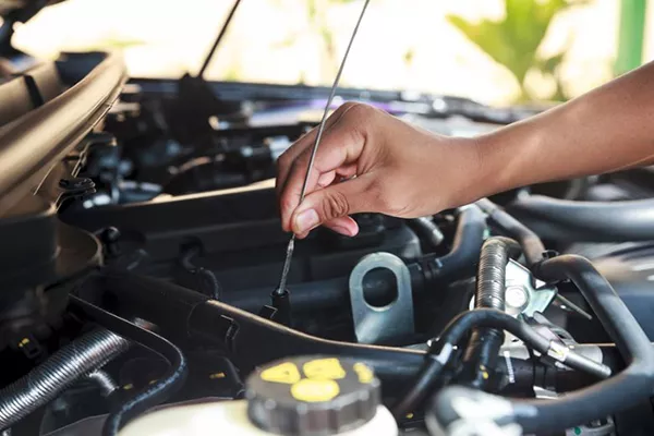 Start by giving your car an overall check and maintenance A picture of a man checking his car's oil