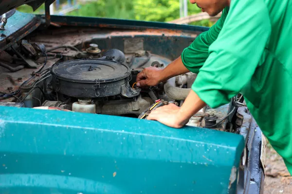 Plot down the estimated total amount you’ll need in order to restore the old car Man checking the engine