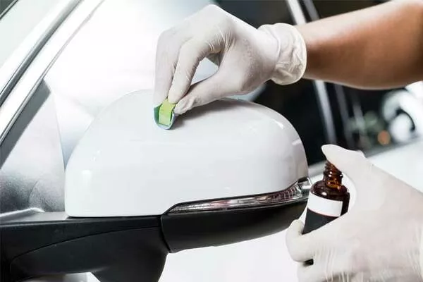 Man applying paint protection to cars