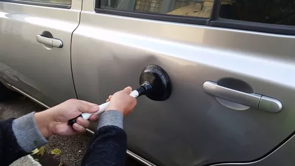Using plunger to remove car dent