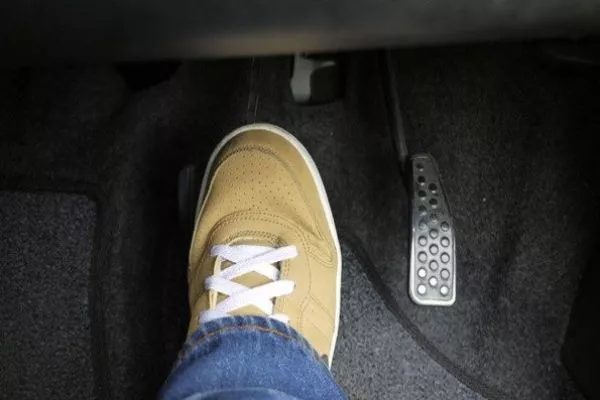 A picture of a foot pressing on a brake pedal