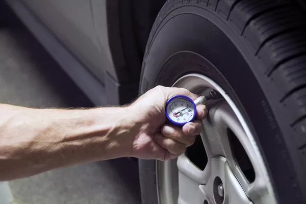 Make sure to always check the tire’s pressure Man checking tire pressure
