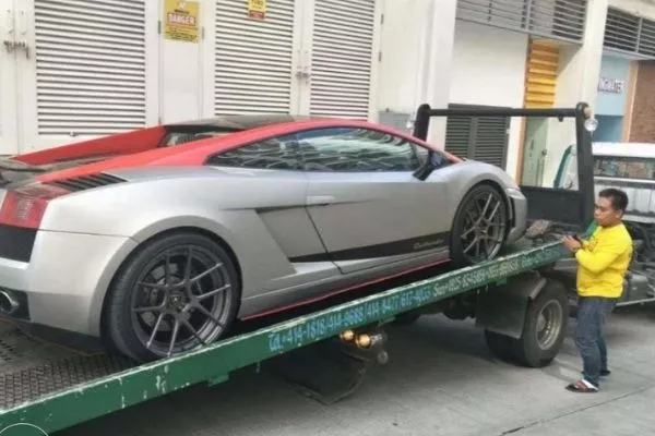 A sportscar being loaded onto a Protech flatbed truck