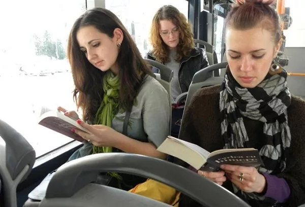 Reading inside a moving vehicle can affect your vision that is why it is highly discouraged women reading book on bus