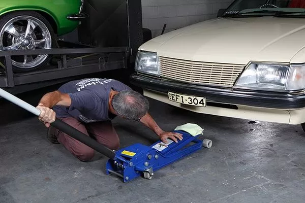 Man putting the jack up on the car