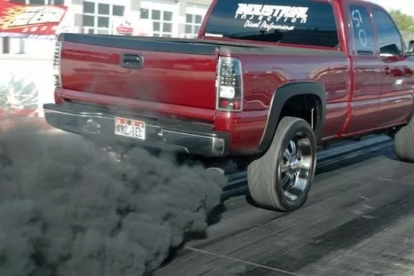 A red truck emitting black smoke