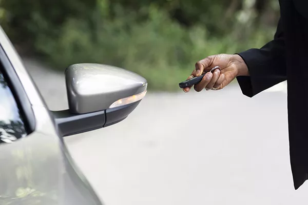 A picture of a man pressing a key fob.