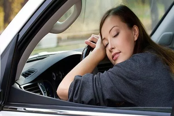 A short 20 minutes of sleep can help you recharge and ready your mind before hitting the road Lady sleeping in the car