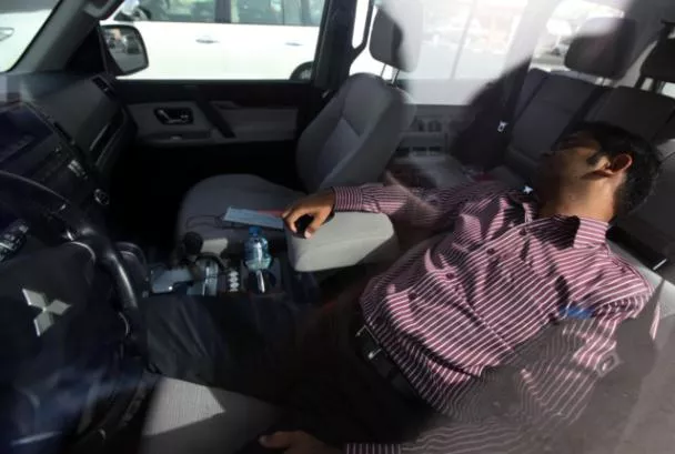 A man sleeping in car with engine on