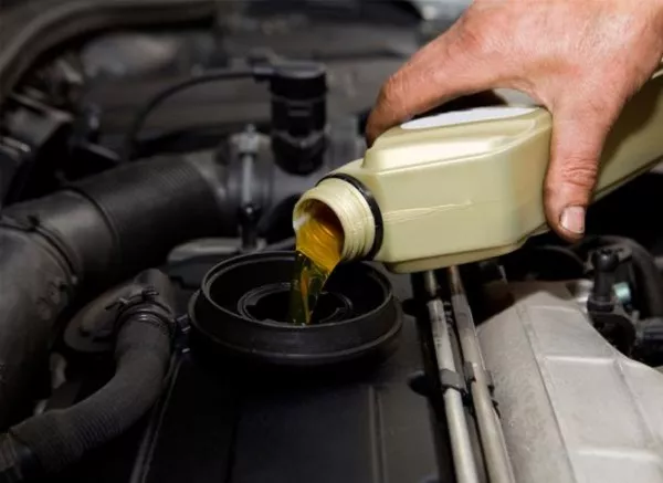 Any dirty engine oil with sediments and junk can only result in two bad things – a defective engine and a costly repair Man pouring engine oil