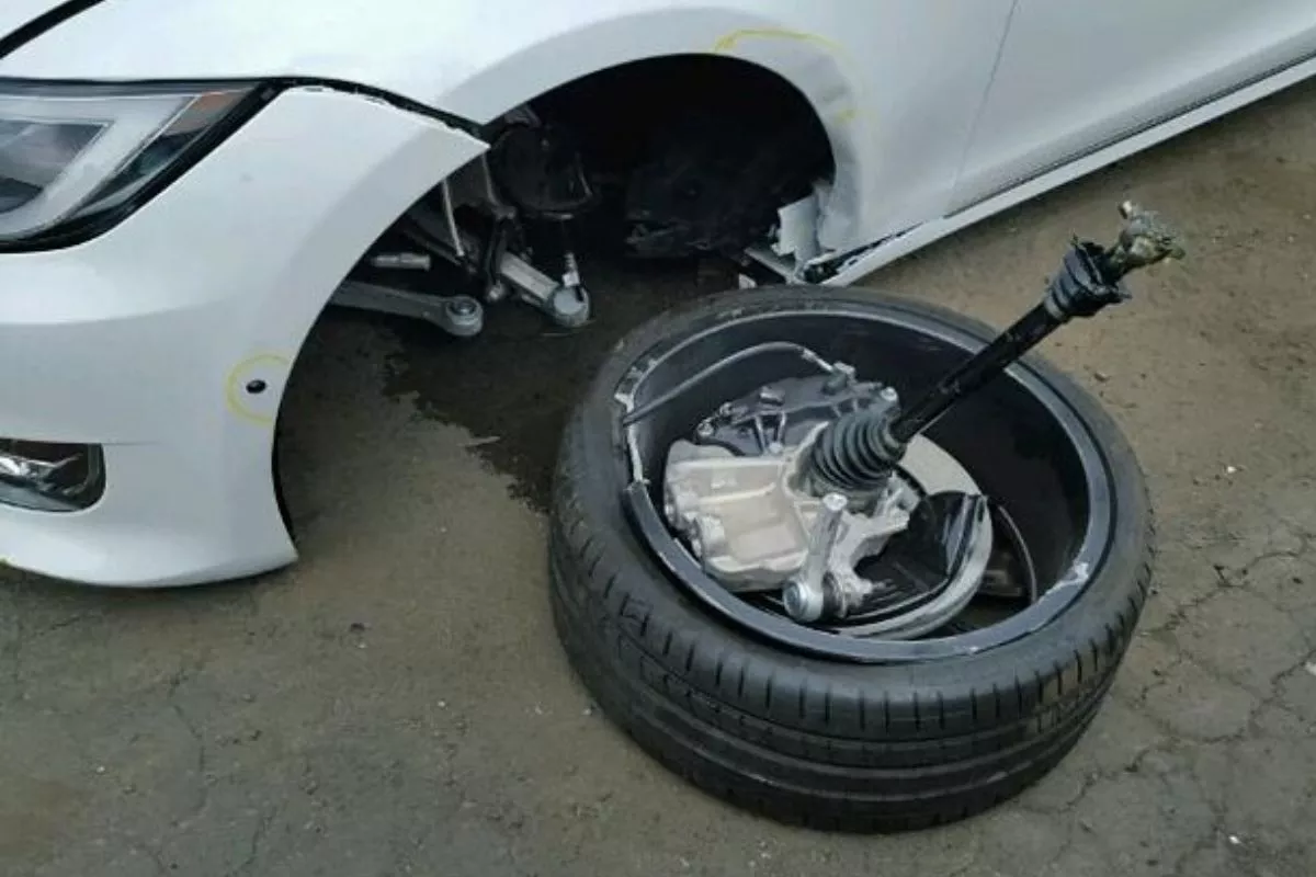 A picture of a parked Tesla with a broken tie rod