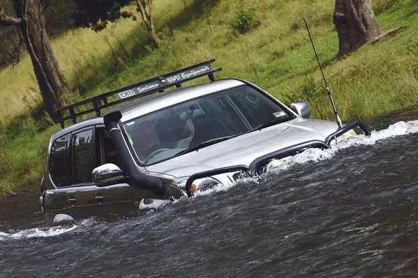 car with snorkel wading through flood