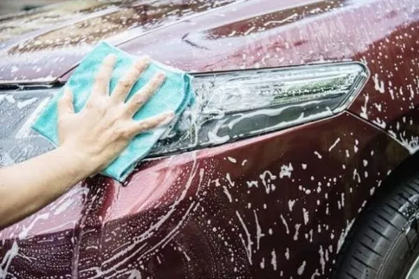 Just like the pre-wash spray, apply the soap from top to bottom A person applying soap to a car
