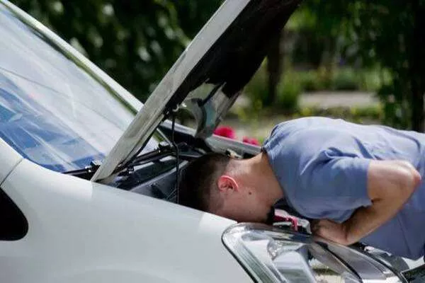 Man checking the car's under-hood