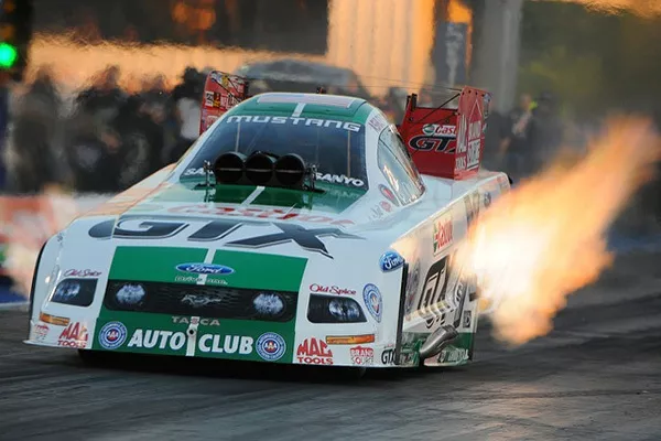 A picture of a top fuel dragster revving at the starting line. 