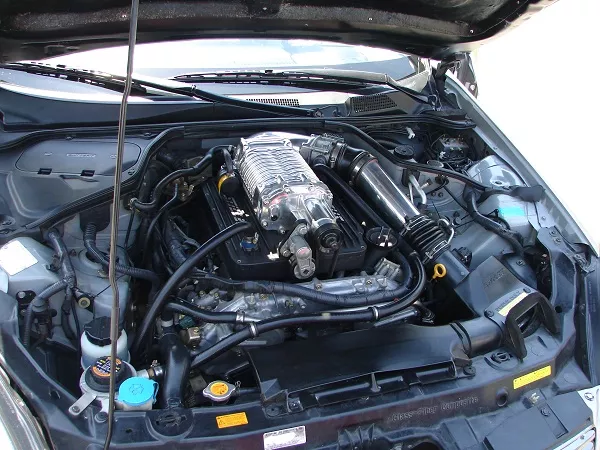 A picture of a 350z displaying its engine and its supercharger