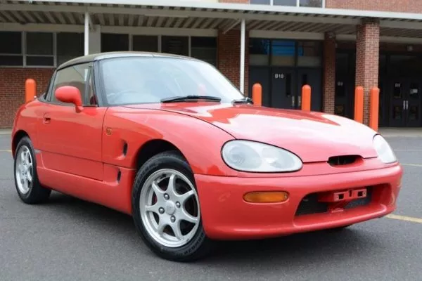 While it has a sub-1-liter engine, said engine has a red-line of 9,300 rpm A picture of a red Suzuki Cappuccino parked on a lot