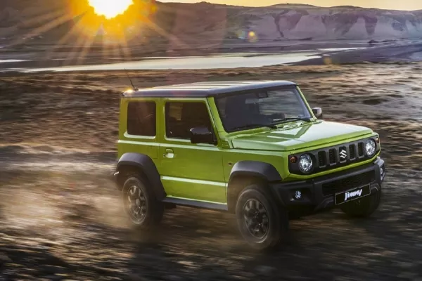 We'll never get used to its timeless round headlamps A Jimny driving through an off-road