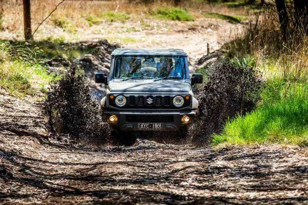A picture of a Suzuki Jimny going through mud